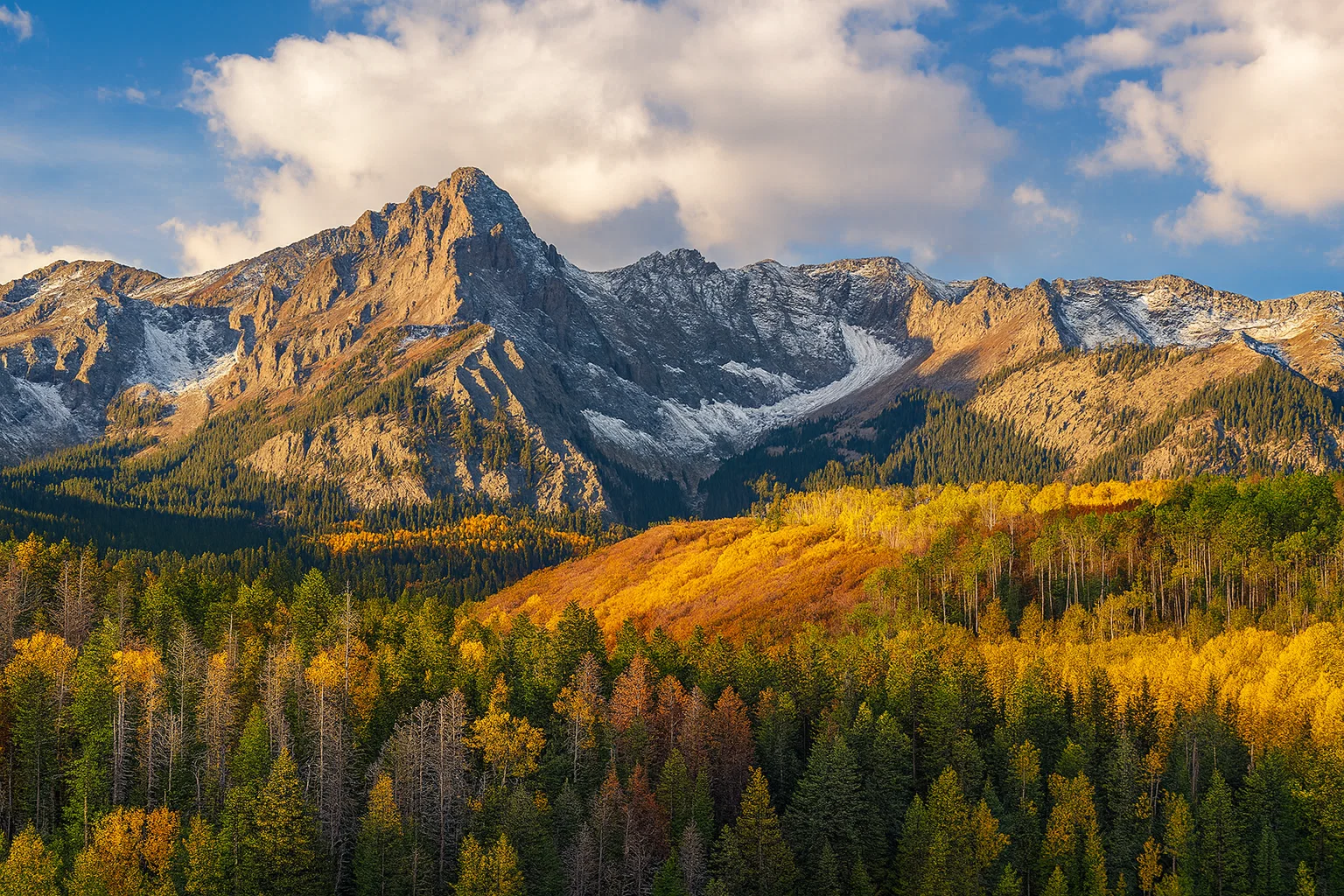 Majestic mountain range with autumn foliage and blue sky, illustrating the photo to music feature for travel landscapes.