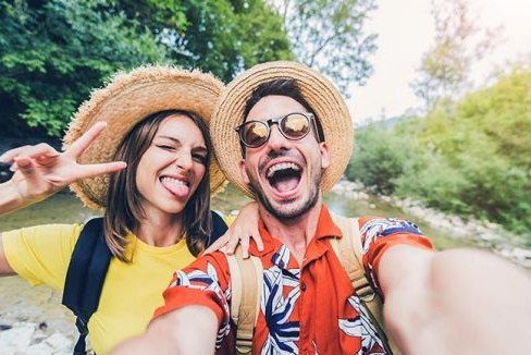Happy couple taking a selfie on vacation, using the image to music generator to capture the mood.